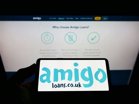 Person Holding Smartphone With Logo Of British Loan Guarantor Amigo