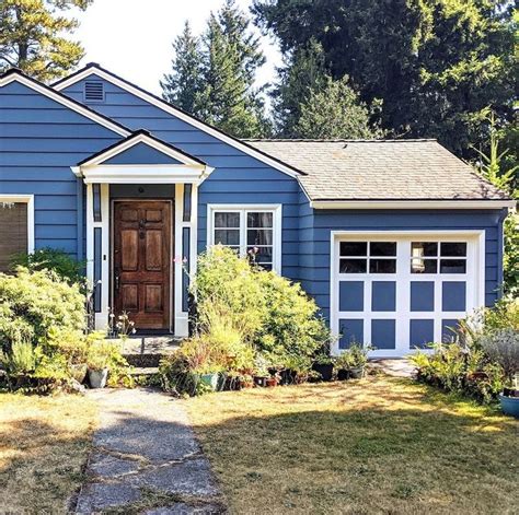 A Blue House With White Trim And Brown Door