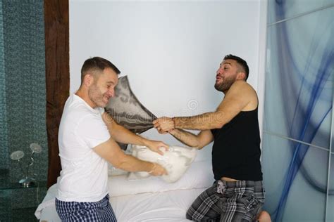 Gay Couple In A Fun Pillow Fight In Bed Stock Image Image Of Boyfriend Love