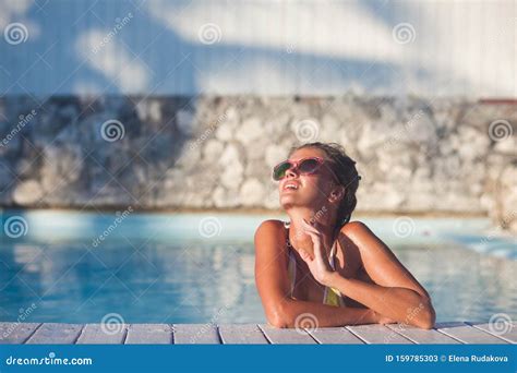 Beautiful Young Woman In Sunglasses With Flower In Hair Smiling In Luxury Pool Stock Image