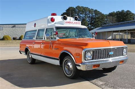 An Orange And White Ambulance Parked In Front Of A Building With The