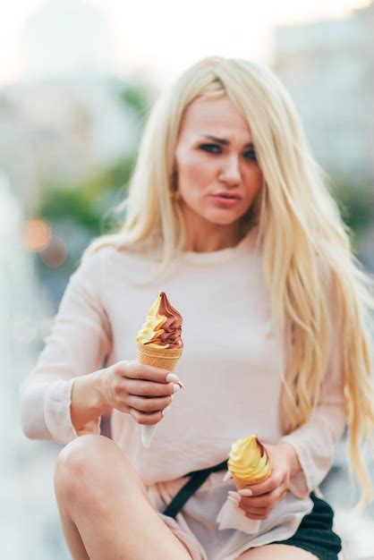 Premium Photo Emotional Woman Blonde With Two Ice Creams Posing Against The Backdrop Of The