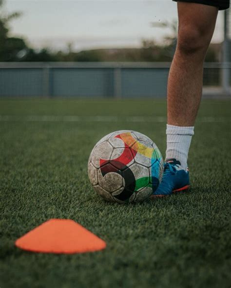 Tiro Vertical De Las Piernas Del Jugador Driblando Conos En El Campo De