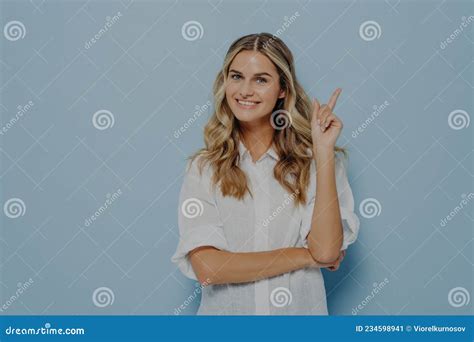 Joyeux Jeune Blonde Jeune Femme Blonde Aux Cheveux Longs Ondulés Pointant Avec L index Vers Le