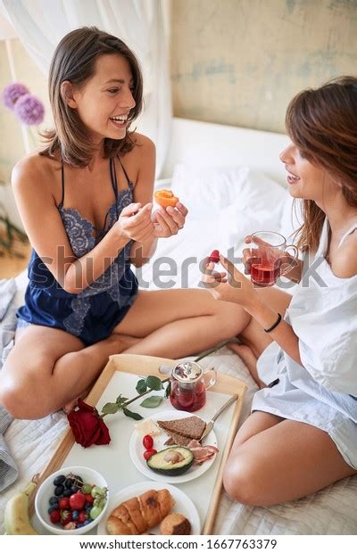 Photo de stock lesbiennes assises jambes croisées petit déjeuner au