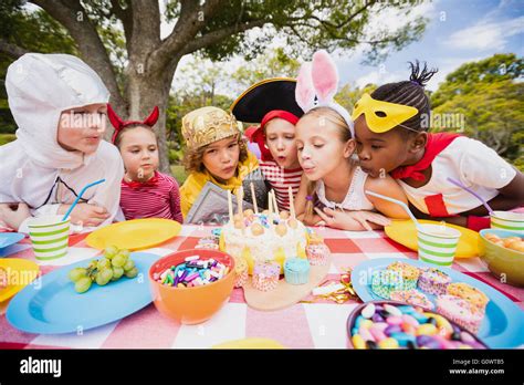 Cute children blowing together on the candle during a birthday party ...