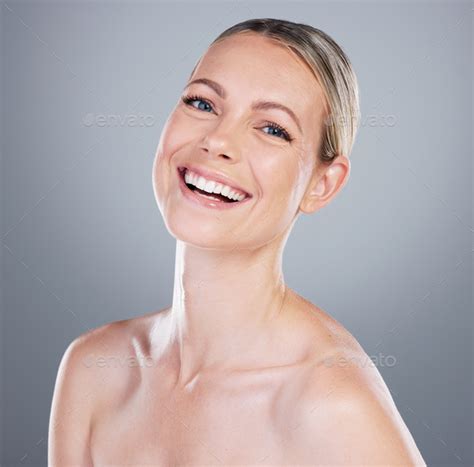 Studio Portrait Of An Attractive Mature Woman Posing Against A Grey Background Stock Photo By