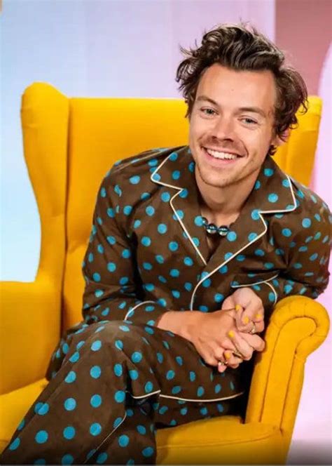 A Man Sitting In A Yellow Chair With Blue Polka Dots On His Pajamas And