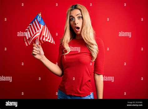 Beautiful Blonde Patriotic Woman Holding United States Flags Celebrating Independence Day Scared