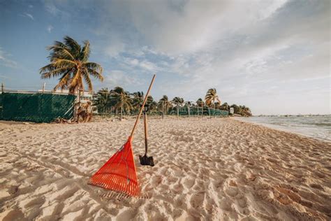 Tools For Cleaning The Beach Rake And Shovel On Sand Stock Photo