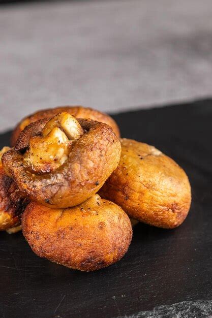 Premium Photo | Grilled portobello mushrooms on black plate brown ...