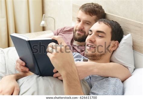 Gay Couple Lying On Bed Reading Stock Photo Edit Now