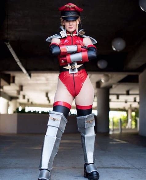 A Woman Dressed In Red And Black Is Posing