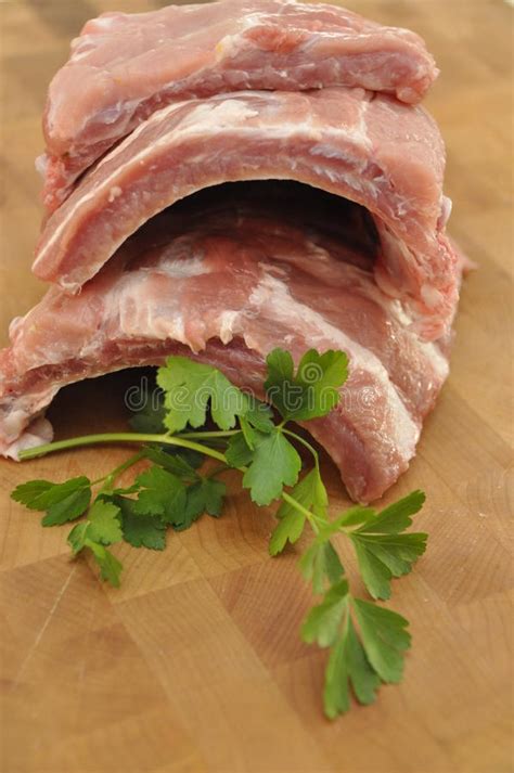 Chuletas De Cerdo Del Cerdo En La Tajadera De Madera Foto De Archivo