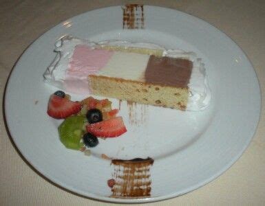 There Is A Piece Of Cake On The Plate With Berries And Kiwis Next To It