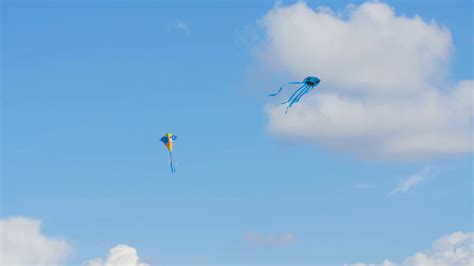 Two Colourful Kites Flying In Blue Sky With Clouds Stock Video Footage