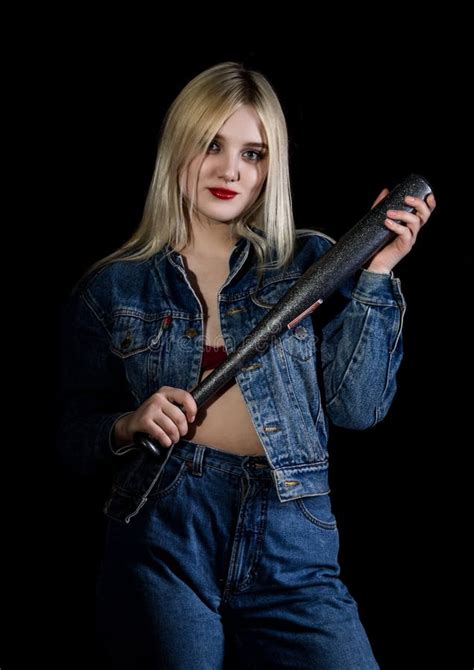 La Jeune Femme Blonde Dans Le Jaket Et Des Jeans De Denim Montre La