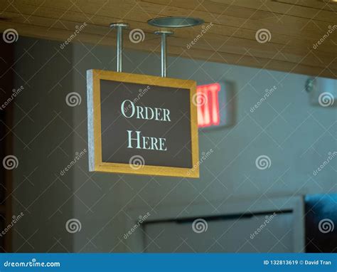 Order Here Sign Hanging From The Top Of A Restaurant Ordering Line