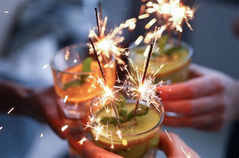 Premium Photo Hands Holding Glasses With Fruit Cocktails And Sparklers