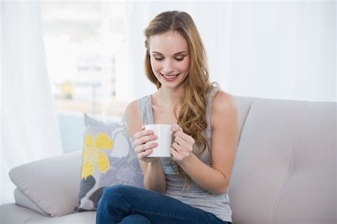 Premium Photo Content Young Woman Sitting On Sofa Holding Mug