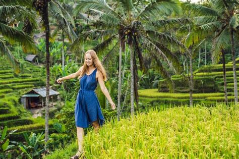 Mujer joven en la plantación de campo de arroz en cascada verde en la