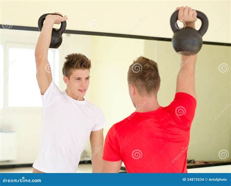 Two Young Men In Gym Working Out With Kettlebells Stock Photo - Image of working, pair: 34873534