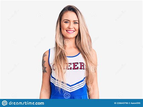 Young Beautiful Blonde Woman Wearing Cheerleader Uniform With A Happy