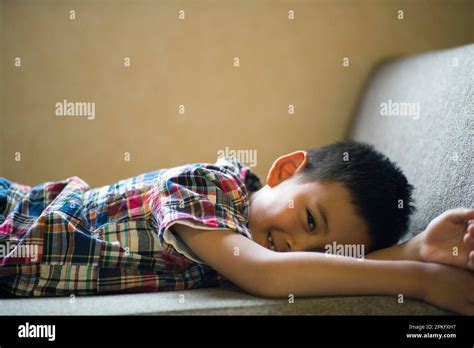 Elementary School Boy Lying On The Sofa Stock Photo Alamy