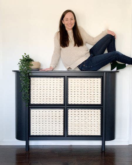 A Woman Sitting On Top Of A Black Cabinet