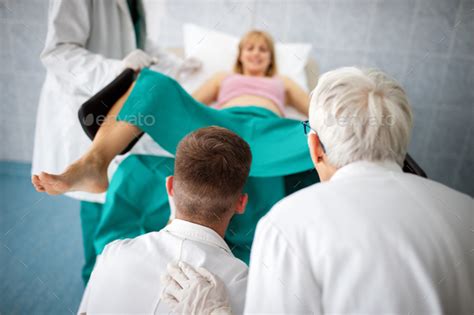 Obstetricians Assisting In The Hospital Woman In Labor Pushes To Give