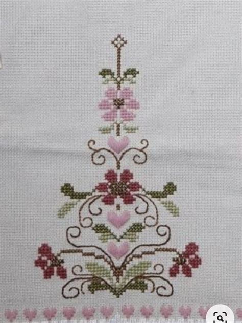 A Cross Stitched Christmas Tree With Hearts And Flowers On The Bottom