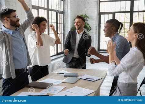 Excited Diverse Employees Celebrating Great Teamwork Result At Meeting