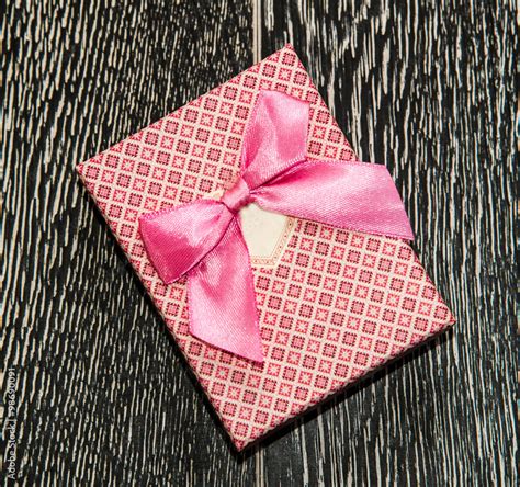 Pink gift box with ribbon bow on dark background Stock Photo | Adobe Stock