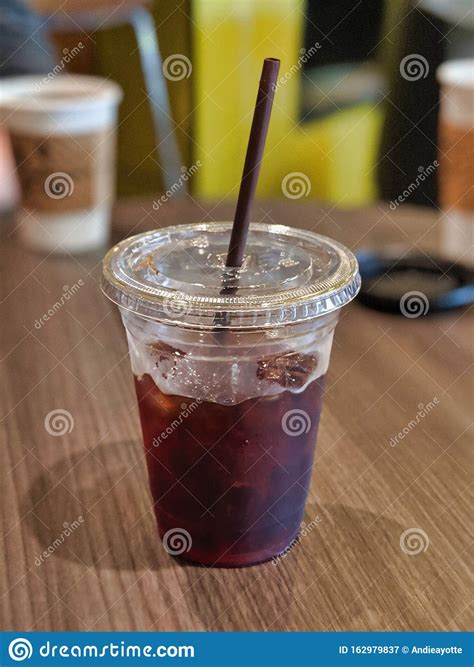 Cold Brew Coffee In A Plastic Cup With Straw Sitting On A Wood Table In A Cozy Cafe Stock Image