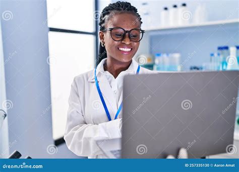 African American Woman Scientist Smiling Confident Using Laptop At