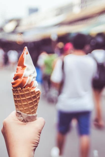 Premium Photo Hand Holding Melting Ice Cream Waffle Cone In Hand On