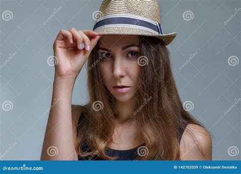 Portrait Of Beautiful Brunette Woman In A Fashionable Hat Is Stylish Posing On Gray Background