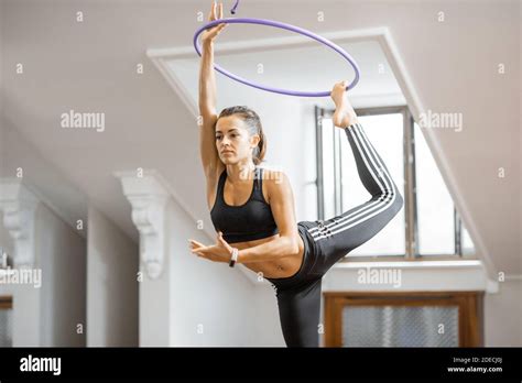 Athletic Woman Practising Rhythmic Gymnastics With A Hoop In The Gym