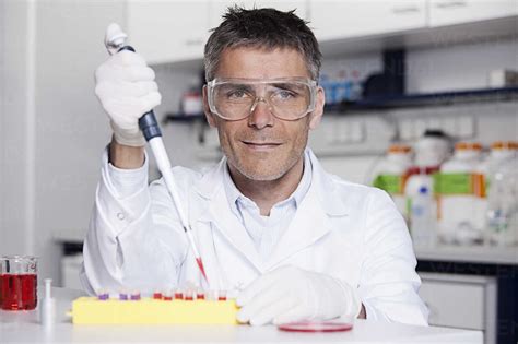 Germany Bavaria Munich Scientist Pouring Red Liquid With Pipette In