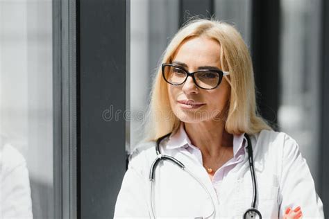 Female Doctor Wearing Lab Coat And Stethoscope And Holding Clipboard In