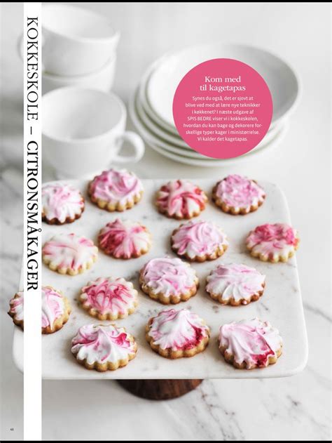 Cookies With Pink Icing On A White Tray Next To Cups And Saucers In The