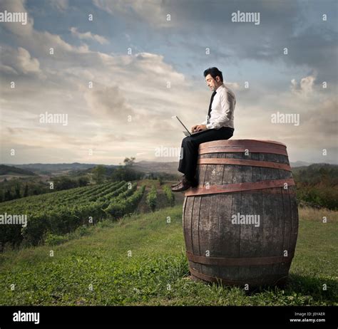 Businessman Sitting On Huge Barrel Stock Photo Alamy