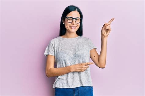 Hermosa Mujer Joven Con Ropa Informal Y Gafas Sonriendo Y Mirando A La