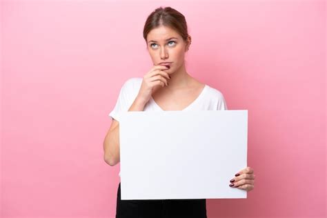 Jovem Mulher Caucasiana Isolada Em Um Fundo Rosa Segurando Um Cartaz