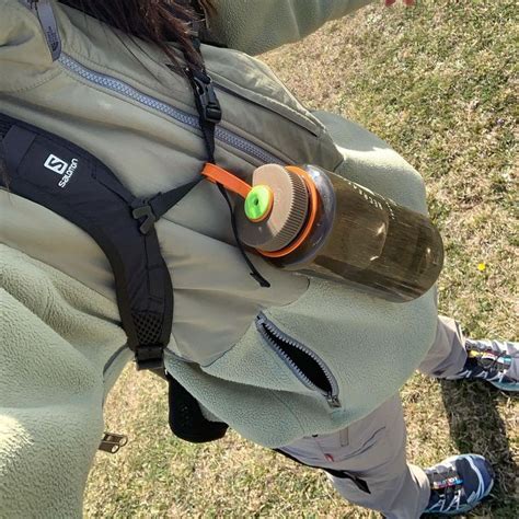 A Person Holding A Water Bottle In Their Back Pocket