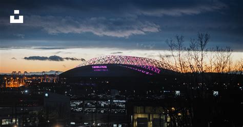 A stadium lit up at night with the lights on photo – Free Arena Image ...