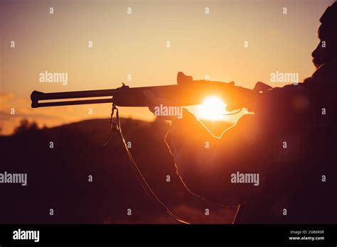 Trigger Of The Shotgun Rifle Hunter Silhouetted In Beautiful Sunset