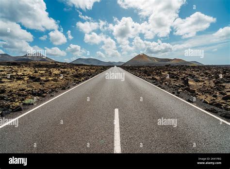 Asphalt Road In Volcanic Arid Landscape Of Timanfaya National Park