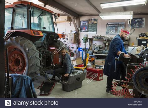 Mechanics Working On Tractor In Workshop Stock Photo Alamy