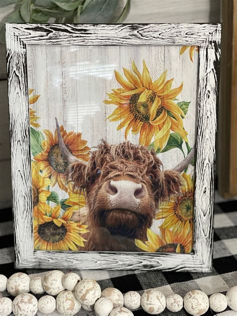 A Photo Frame With A Cow And Sunflowers Painted On It Next To Some Eggs